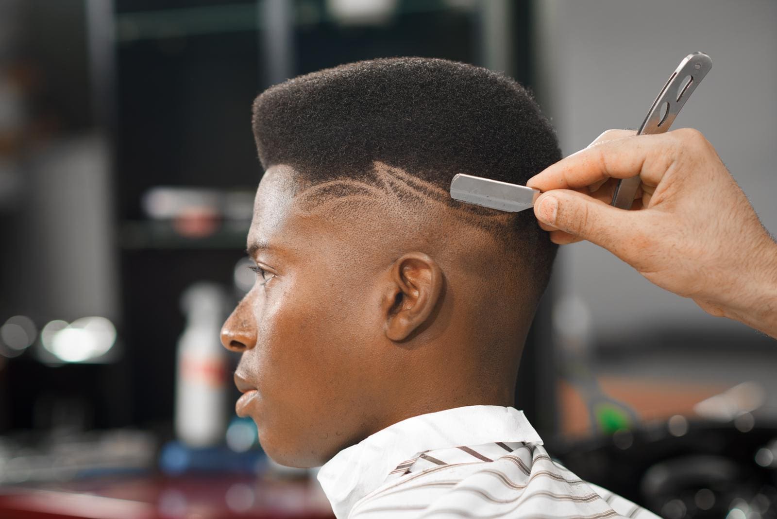 A man getting his hair cut by another person