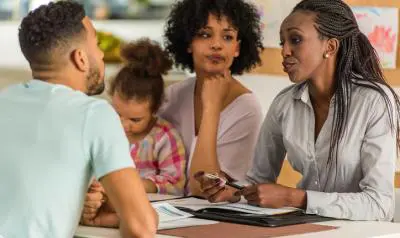 A group of people sitting at a table with papers.