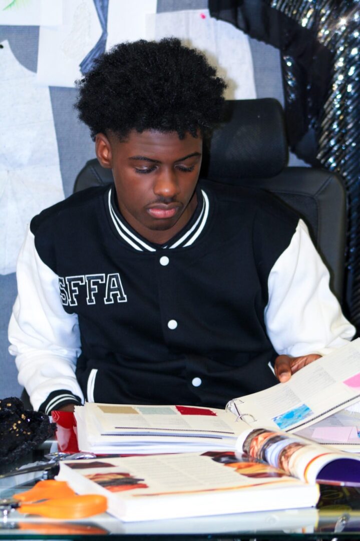 A man sitting at a table reading a book.