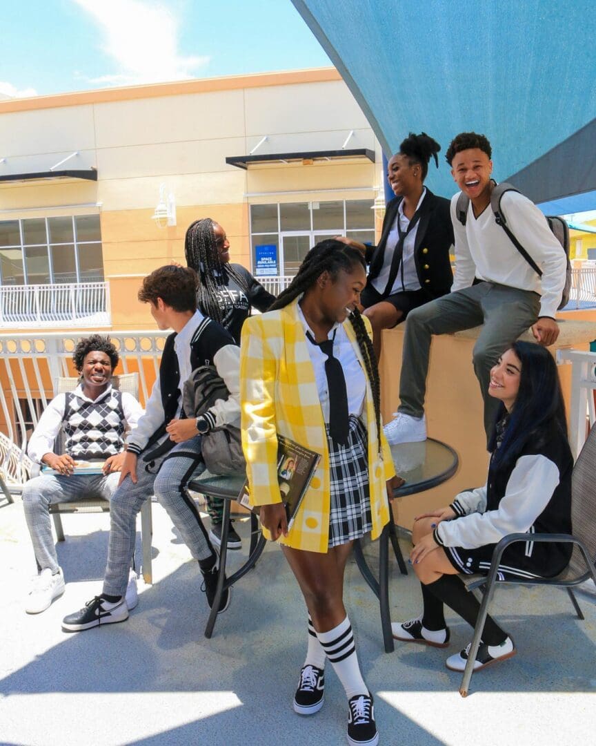 A group of people sitting on chairs and standing around.