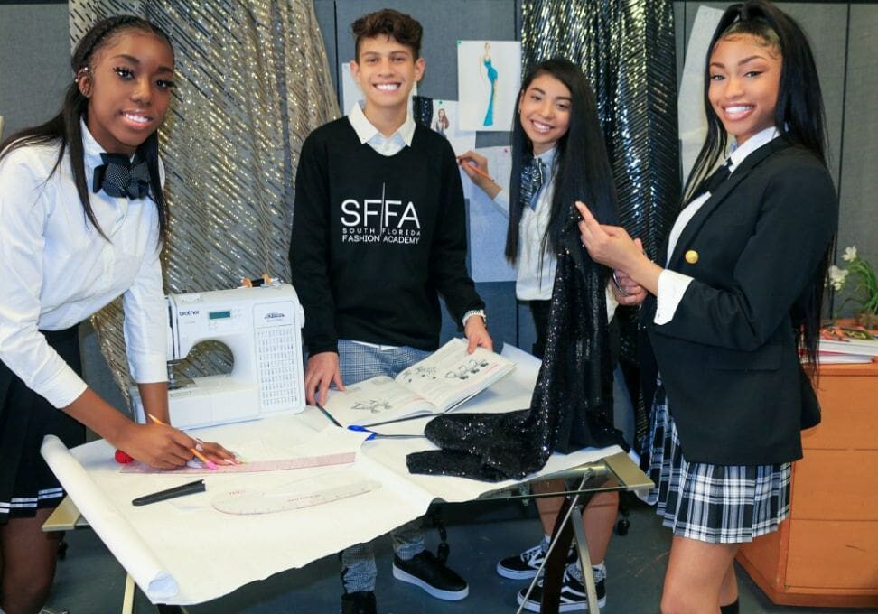 A group of young people standing around a table.