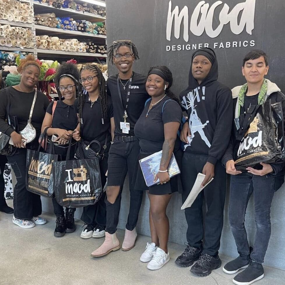 A group of people standing in front of a store.