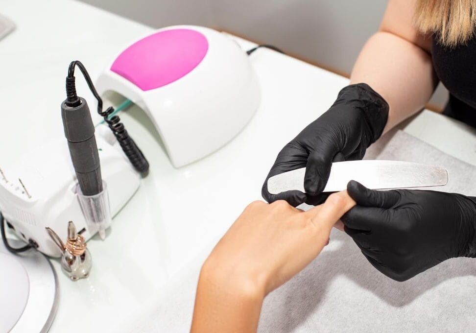 A person getting their nails done in the salon.