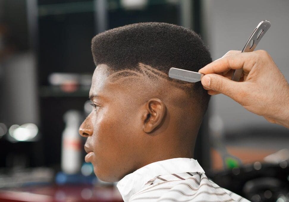 A man getting his hair cut by another person